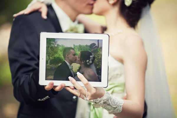 Svatba. nevěsta a ženich líbat a drželi se za ruce v tabletu — Stock fotografie