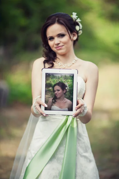 Bruiloft. mooie bruid houden een tablet, maar binnen hamming — Stockfoto