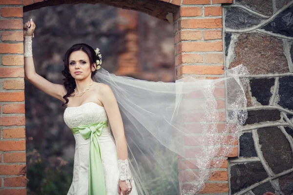 Casamento. noiva abraçando contra o pano de fundo de um edifício antigo — Fotografia de Stock