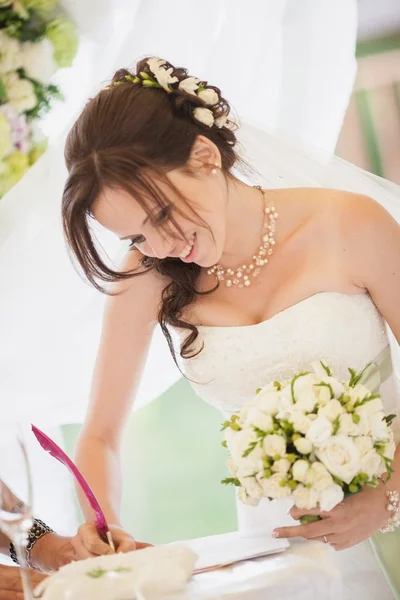 Bride signing wedding certificate in park — Stock Photo, Image