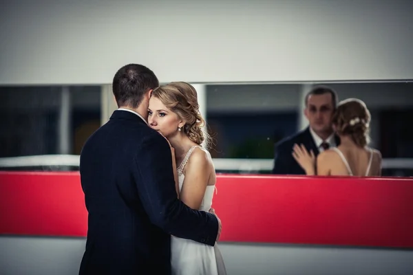 Boda. la pareja abrazándose y el fondo del espejo se ven a sí mismos — Foto de Stock