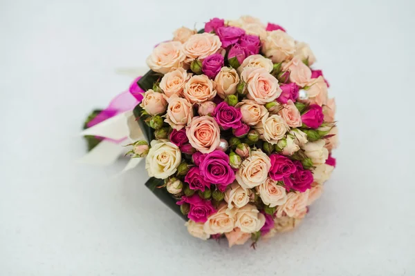 Свадебный букет из роз, лежащих в снегу — стоковое фото