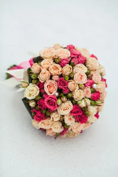 Bouquet de roses de mariage couché dans la neige — Photo