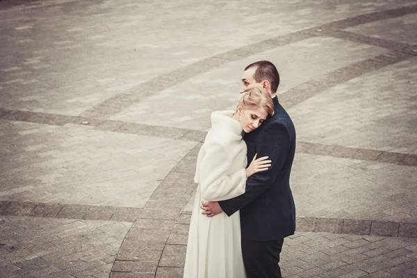 Svatba. nevěsta objetí ženicha a na pozadí krásné pozadí dlaždic — Stock fotografie