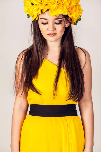 Modell i en gul klänning och en vacker krans på huvudet — Stockfoto