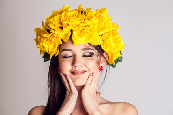 Modelo em um vestido amarelo e uma bela coroa de flores em sua cabeça — Fotografia de Stock