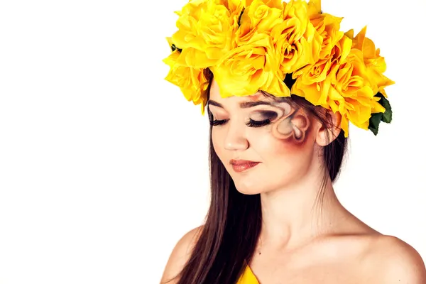 Modelo em um vestido amarelo e uma bela coroa de flores em sua cabeça — Fotografia de Stock