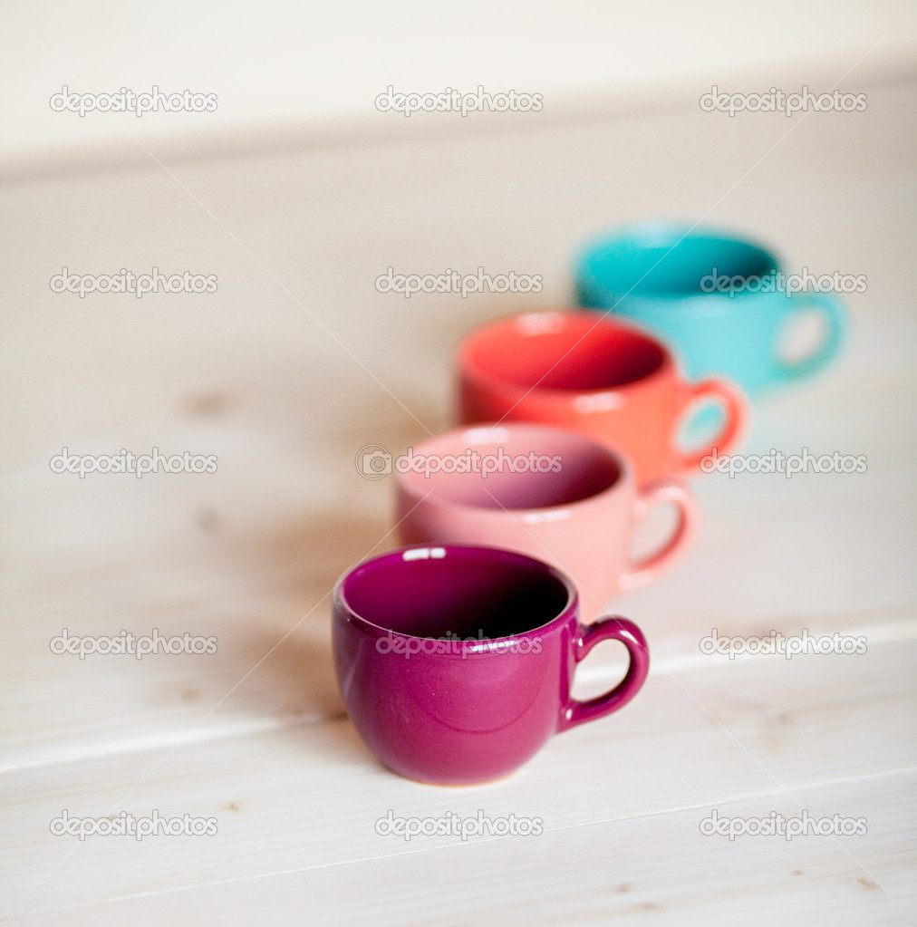 Colorful coffee cups over obsolete grunge wooden background