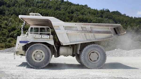 採石場のホワイトホールトラック 大小関節式ダンプカー ダンプカートレーラー ダンプローリー 2軸の高速道路のヘビーデューティー建設環境 ストック画像