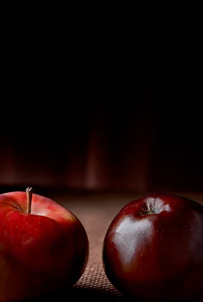 Maçãs. Duas maçãs vermelhas de perto dispostas no fundo escuro — Fotografia de Stock