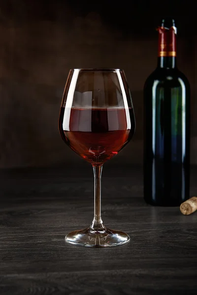 Élégant verre à vin rouge et une bouteille de vin — Photo