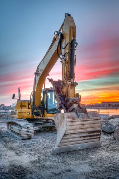 Graafmachine op zonsondergang landschap — Stockfoto