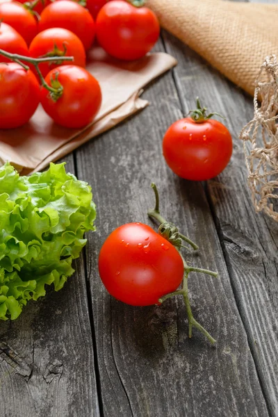 Tomatoes and salad on old grey wood — Stock Photo, Image