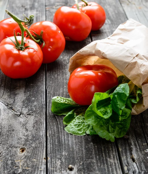 Tomates e salada em madeira cinza velha — Fotografia de Stock