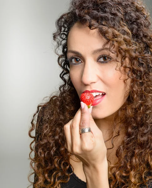 Attractive woman eating strawberry — Stock Photo, Image