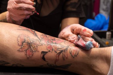 Cildindeki dövme mürekkebini temizliyorum.