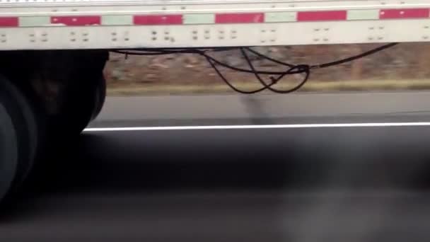 通过美国的红色重型卡车在道路上的侧面低视 同时通过 沥青上的车轮视图 — 图库视频影像