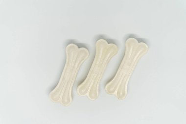 Beyaz arka planda vitaminleri olan bir köpek için yapay kemik, üç parça.