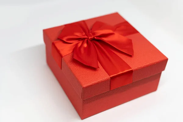 Красная коробка с луком на белом фоне — стоковое фото