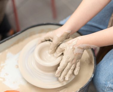 Seramik sınıfında el yapımı seramik yapan bir çocuğun yakın çekimi.