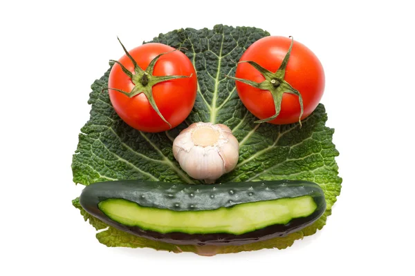 Viso vegetale composto da due pomodori, aglio e cetriolo su foglia verde isolata — Foto Stock