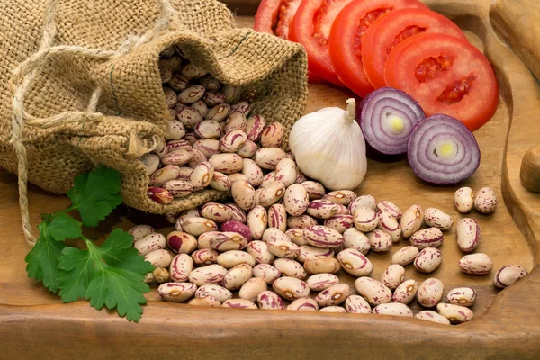 Fagioli versati fuori dalla borsa con i pomodori tritati, cipolle, aglio, pepe e prezzemolo — Foto Stock