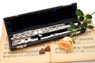 Gümüş flüt, müzik puanı zemin üzerine Sarı Gül ve çikolata Kalpler