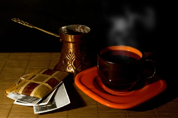 Tasse de café, cafetière et album avec de vieilles photos sur un tapis en bois — Photo