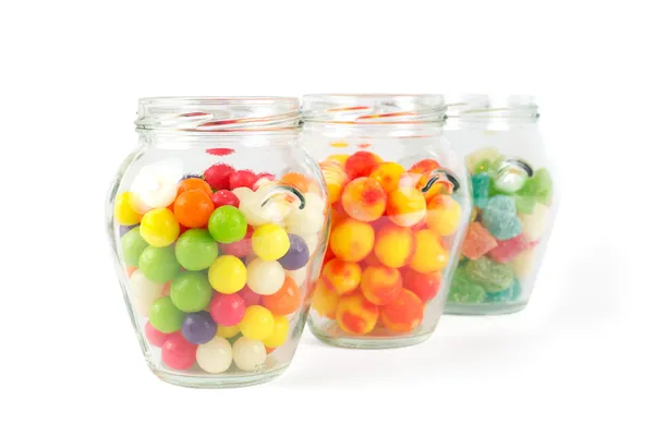 Glass jars filled with different colorful candies isolated on white — Stock Photo, Image