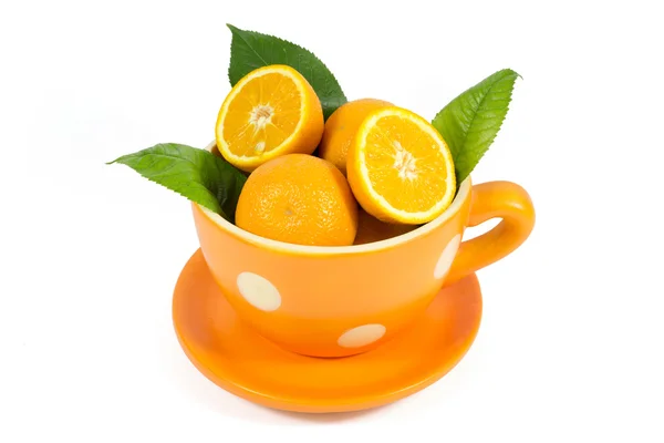 绿色的叶子中分离出白色衬底上的陶瓷碗的橙色水果 — 图库照片