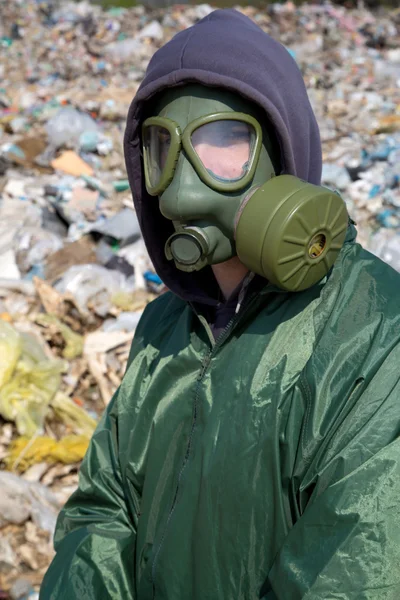 Man in a gas mask against polluted nature — Stock Photo, Image