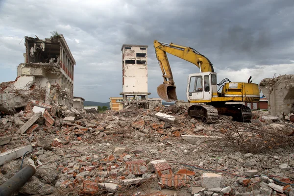 Bulldozer remove os detritos da demolição de antigos edifícios abandonados — Fotografia de Stock
