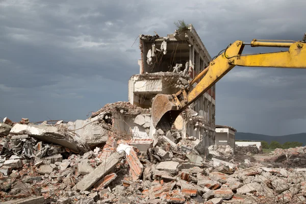 Bulldozer elimina los escombros de la demolición de viejos edificios abandonados — Foto de Stock