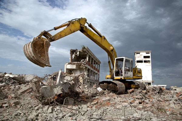 Bulldozer verwijdert het puin van de sloop van oude verwaarloosde gebouwen — Stockfoto