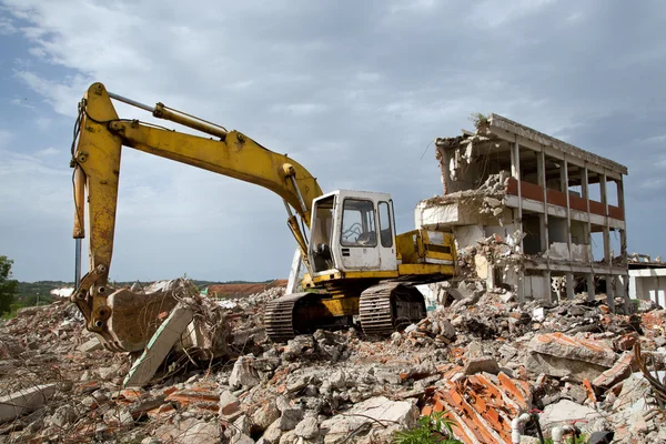 Bulldozer tar bort skräp från rivning av gamla övergivna byggnader — Stockfoto