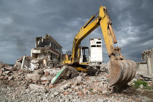 Bulldozer tar bort skräp från rivning av gamla övergivna byggnader — Stockfoto