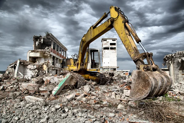 Bulldozer tar bort skräp från rivning av gamla övergivna byggnader — Stockfoto