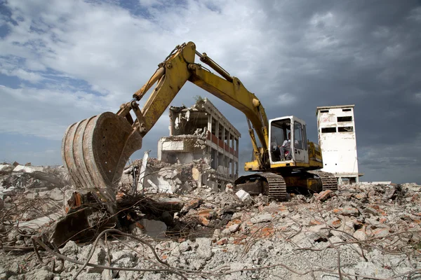 Bulldozer verwijdert het puin van de sloop van oude verwaarloosde gebouwen — Stockfoto