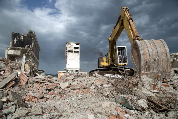 Bulldozer verwijdert het puin van de sloop van oude verwaarloosde gebouwen — Stockfoto