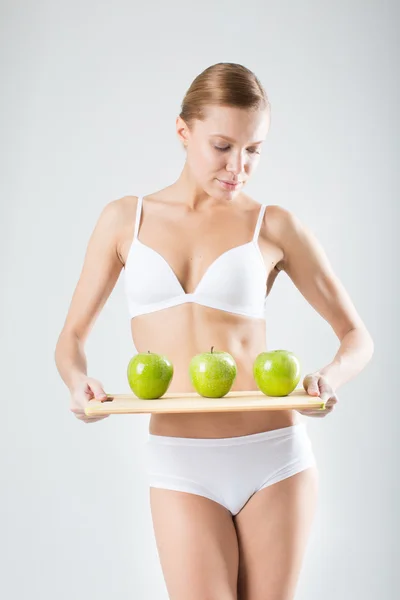 Joven delgada chica sosteniendo una manzana verde — Foto de Stock