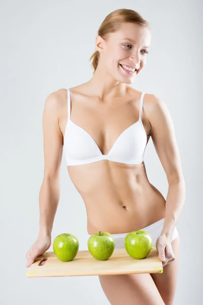 Joven delgada chica sosteniendo una manzana verde — Foto de Stock