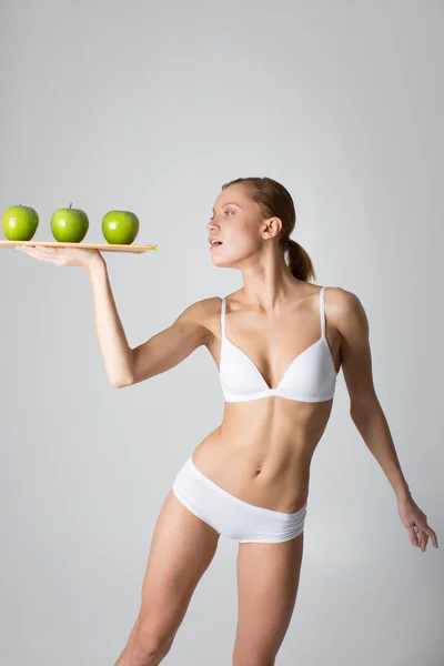 Young slim girl holding a green apple — Stock Photo, Image