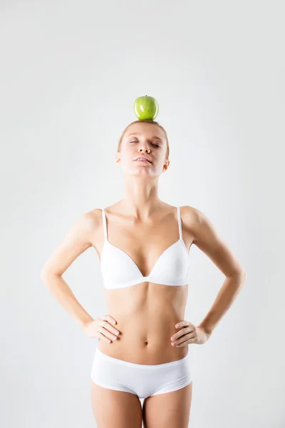 Joven delgada chica sosteniendo una manzana verde — Foto de Stock