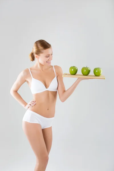 Joven delgada chica sosteniendo una manzana verde — Foto de Stock