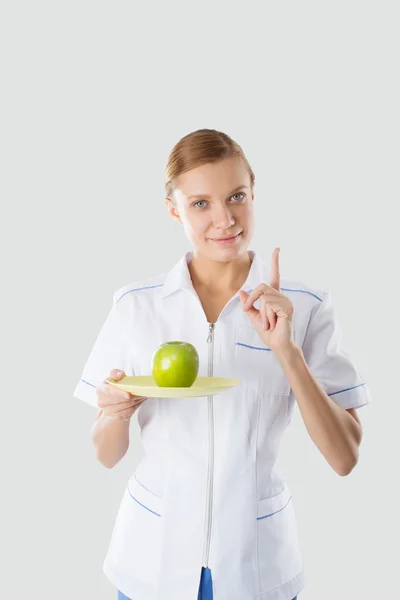 Ernährungswissenschaftlerin hält grünen Apfel an der Hand und misst — Stockfoto