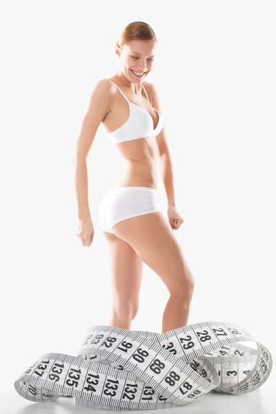 Junge Fitness-Mädchen Unterwäsche in Messzahlen engagiert — Stockfoto