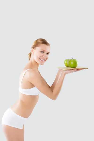 Fitness joven en lencería sosteniendo una manzana verde — Foto de Stock