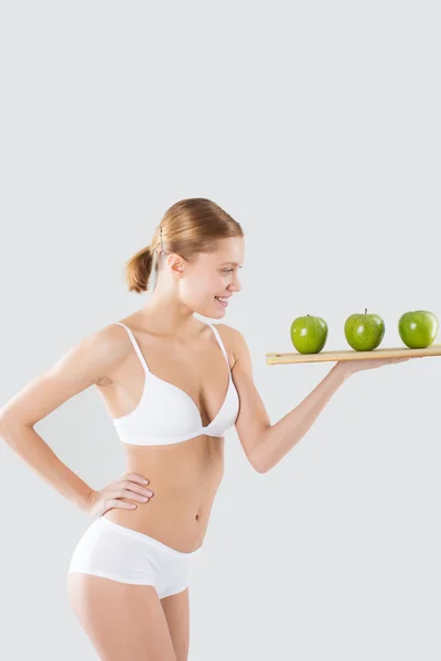 Fitness joven en lencería sosteniendo una manzana verde —  Fotos de Stock