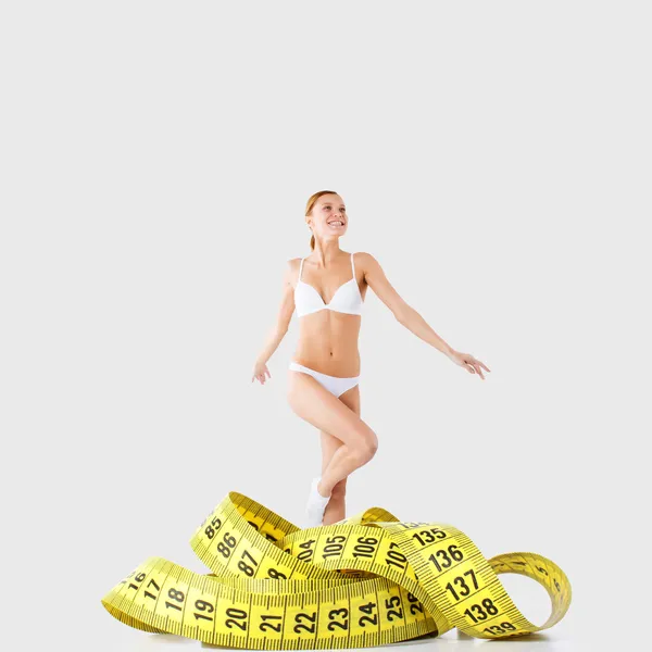 Young fitness girl underwear engaged in measurement figures — Stock Photo, Image