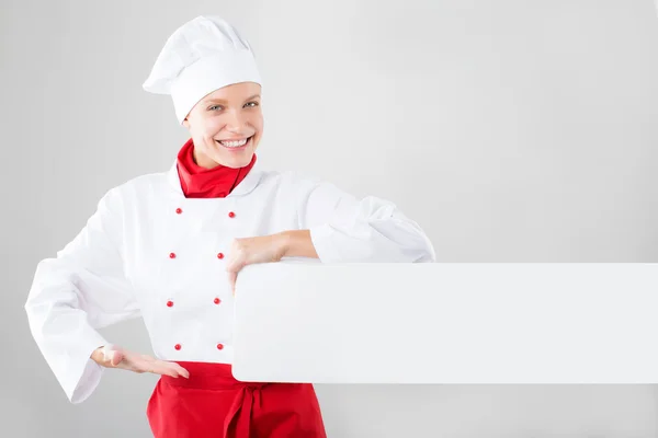 Дівчина, одягнена як кухарські руки, тримає білий банер — стокове фото